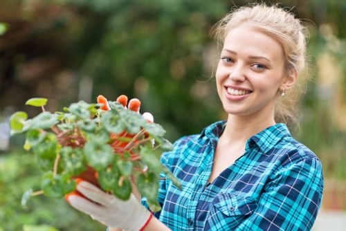 Gardener trimming a formal hedge in Westminster terrace garden